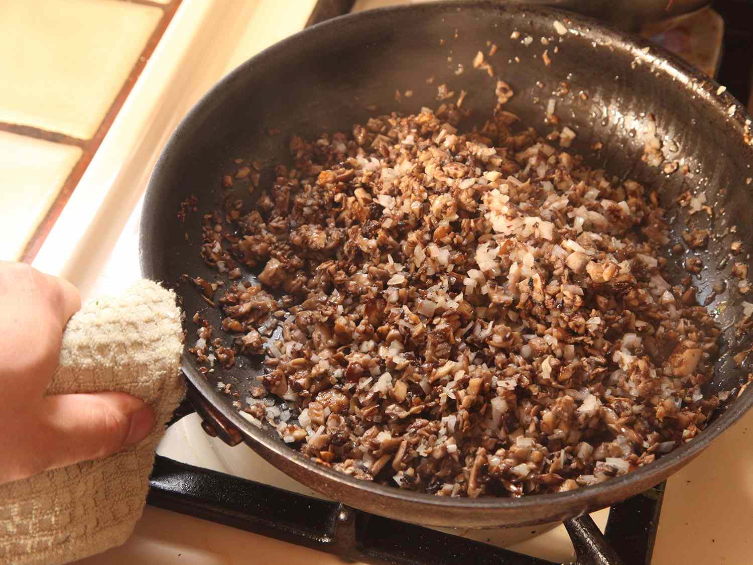 蘑菇丁，青葱和大蒜在煎锅中烹饪。