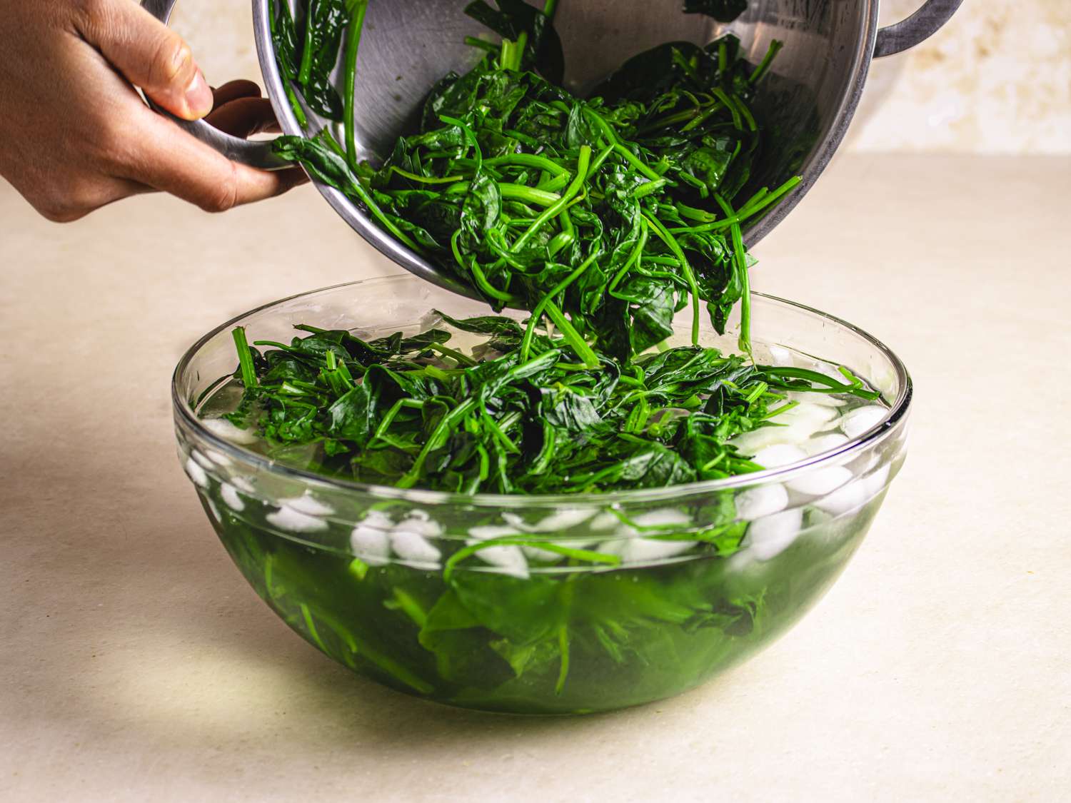 Side view of greens being transferred into an ice bath