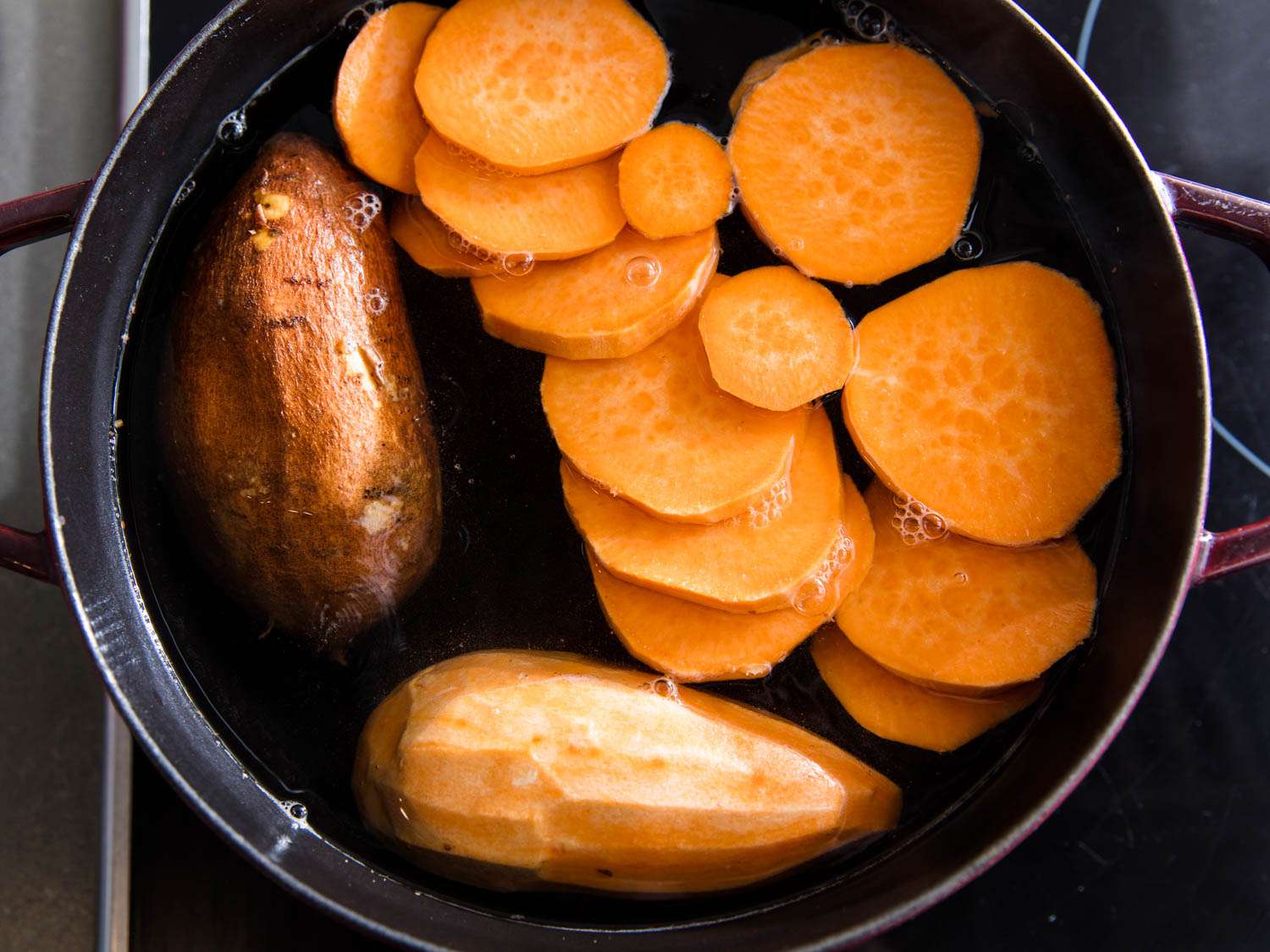 三种准备的红薯(一种去皮，一种去皮，一种去皮切片)放在炉子上的一锅水里。gydF4y2Ba