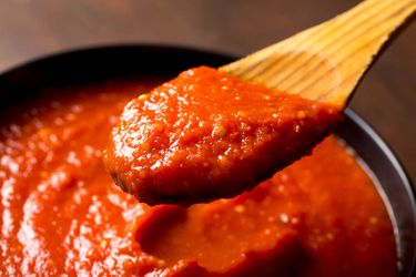 一个木勺舀出一份快速简便的意式美式红酱，尝起来就像你花了一整天做番茄酱。