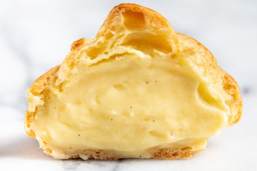 泡芙泡芙里塞满了奶油，切成两半这样你就能看到香草奶油了
