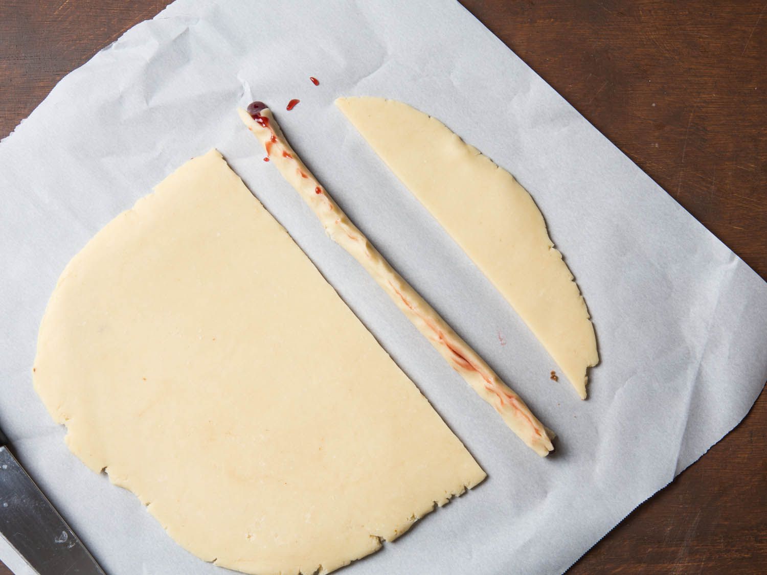 Rolling up a filled piece of with finger cookie dough.