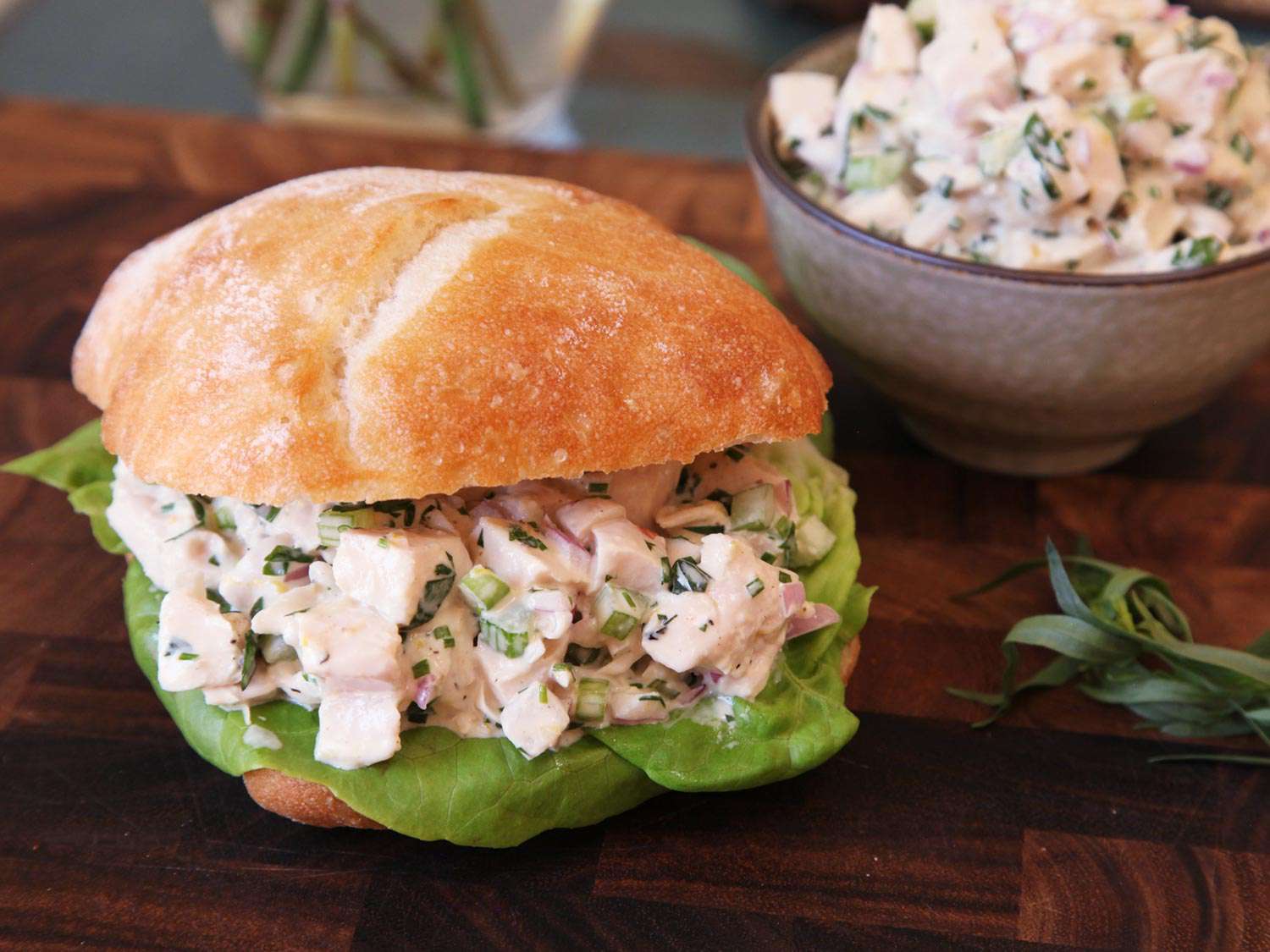 A sandwich roll stuffed with sous vide chicken salad on a bed of lettuce