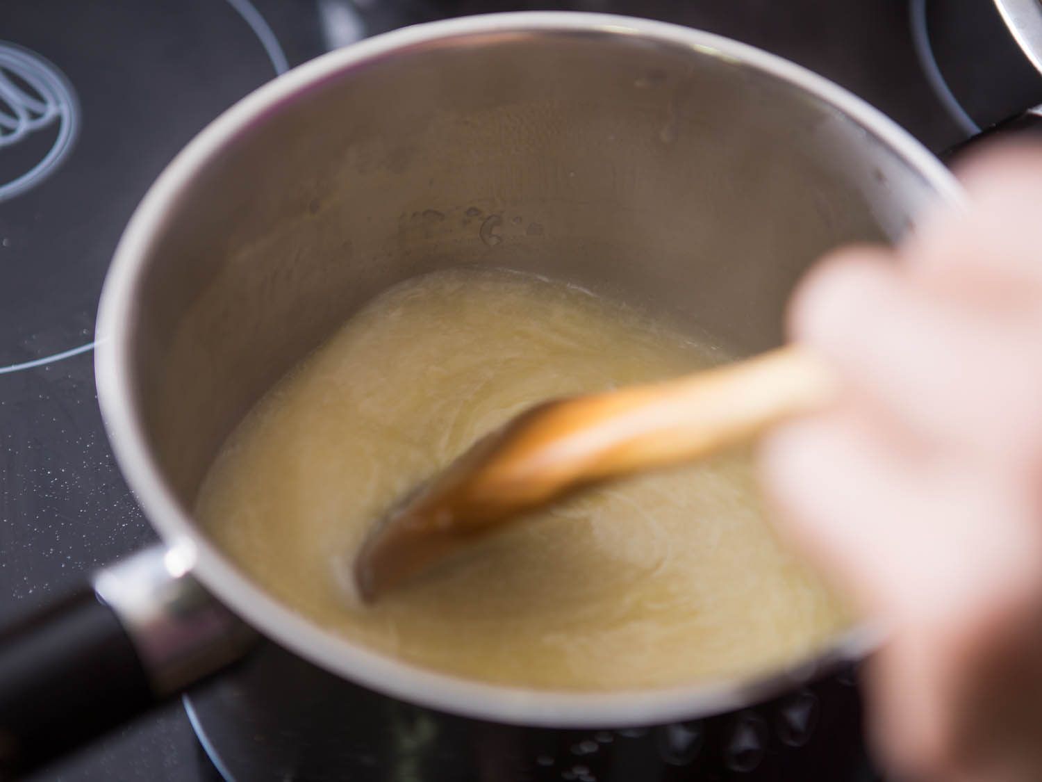 用木勺搅拌干酪。