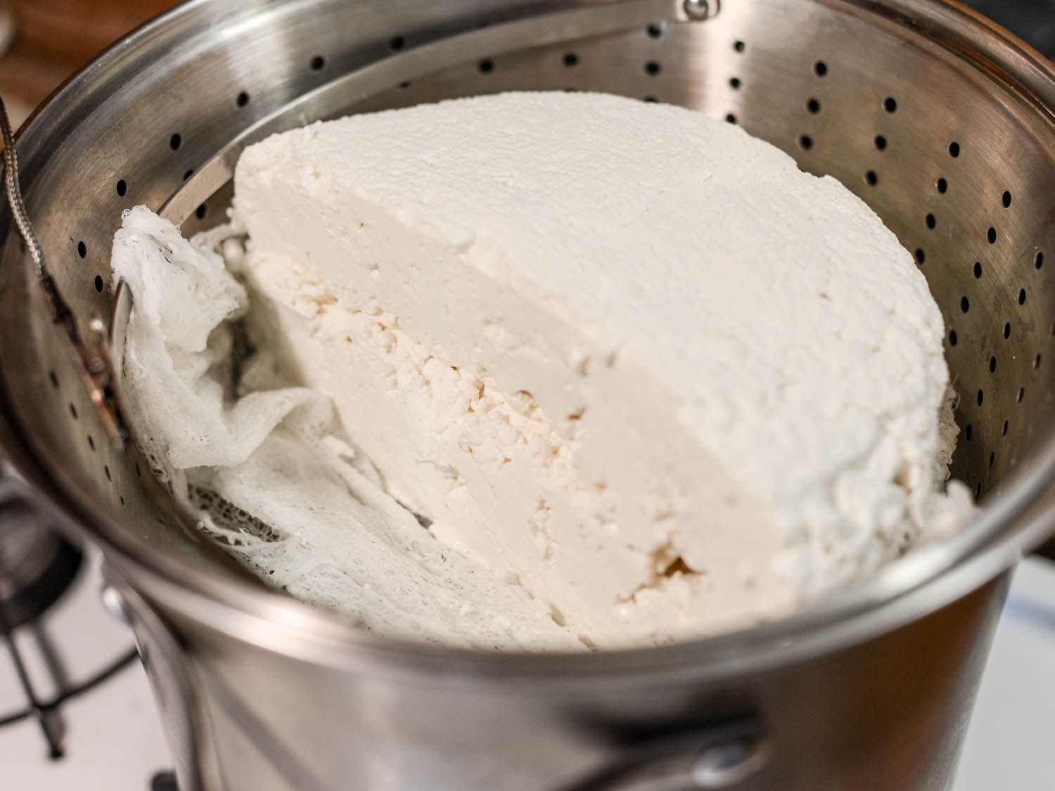 奶酪凝块沉淀在蒸锅插入热乳清锅。