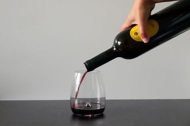 pouring red wine into waterford stemless wine glass