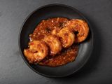 Ebichiri shrimp served on a black round plate.