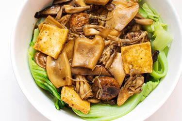 Overhead view of braised mushrooms, tofu, and Chinese mustard greens