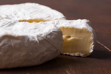 一片切好的布里奶酪，微微拉开，以展示里面的奶油味。