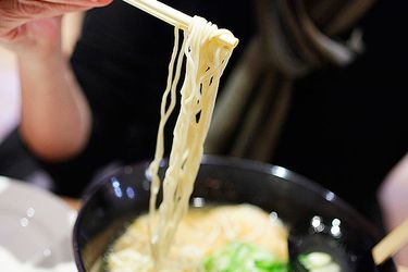 Ramen being pulled from a bowl with chopsticks