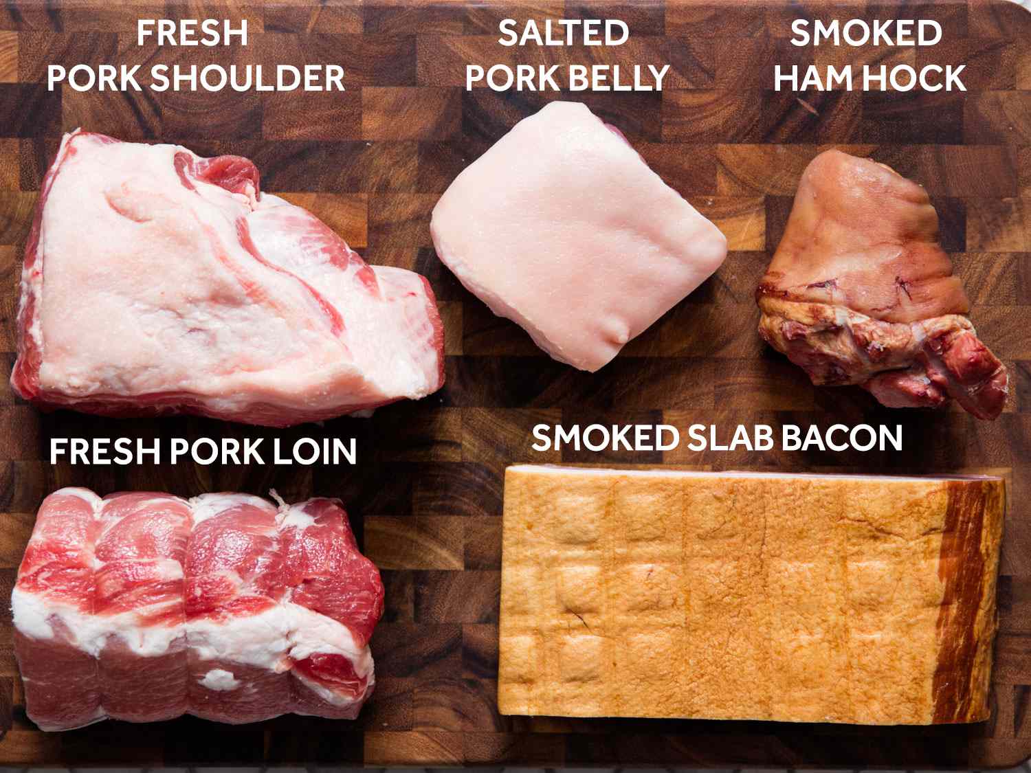 choucroute garnie所需的所有肉类(除了香肠)都被放在砧板上，并贴上标签:新鲜猪肩肉、咸肉五花肉、烟熏火腿节、新鲜猪里脊肉、烟熏大块培根。gydF4y2Ba