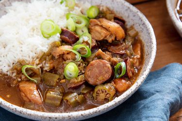 Bowl of Cajun gumbo with chicken, okra, and andouille sausage that is served with rice.
