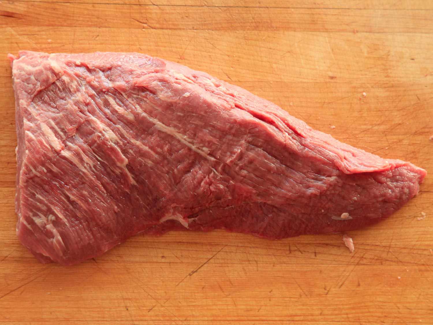 Raw tri-tip steak on a wooden surface