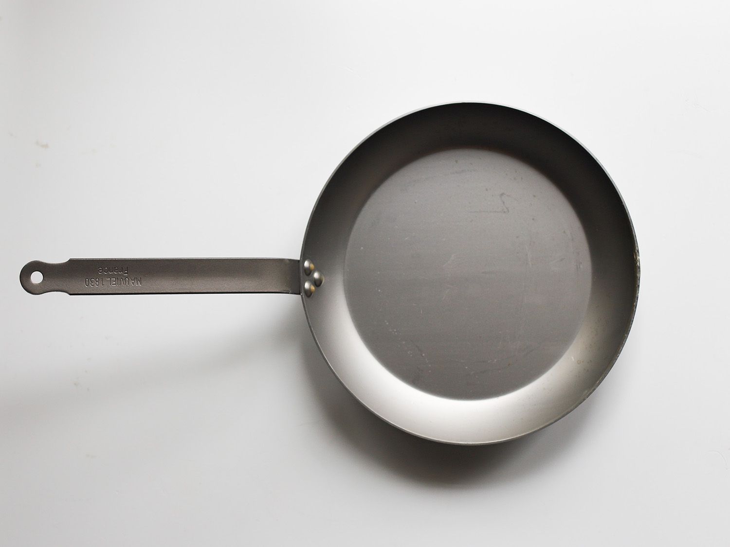 mauviel carbon steel skillet on a white surface