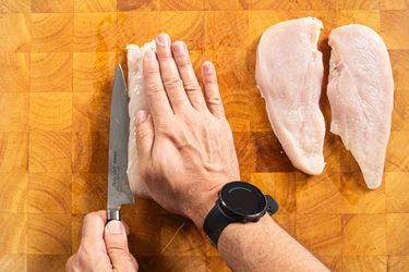 Overhead view of cutting chicken cutlets