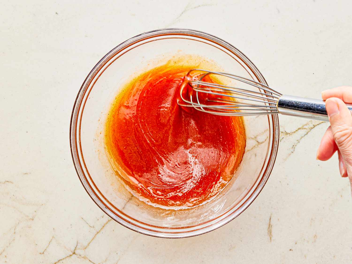 Overhead view of whisking hot sauce dressing together