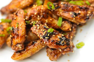 hoisin chicken wings garnished with sesame seeds and chopped scallion green