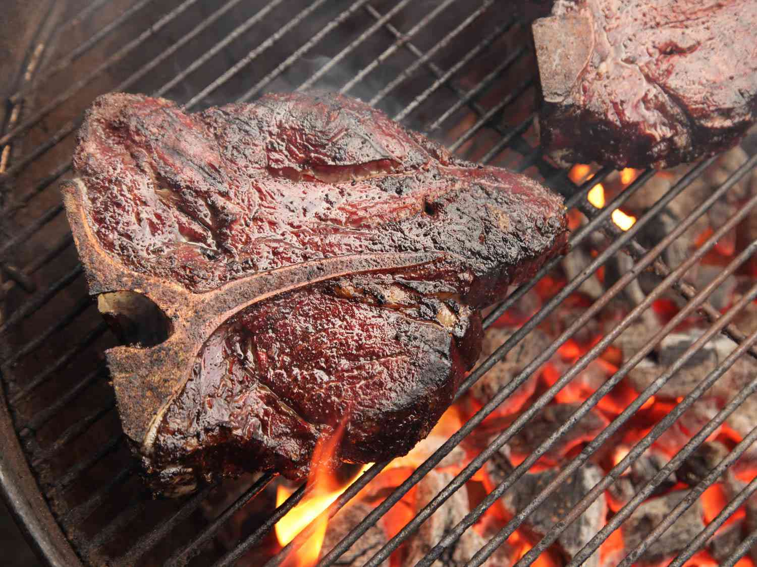 A cooked porterhouse steak on a hot grill.