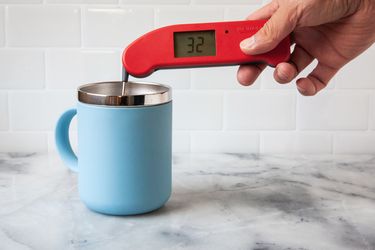 A person using a Thermapen ONE to take the temperature of ice water