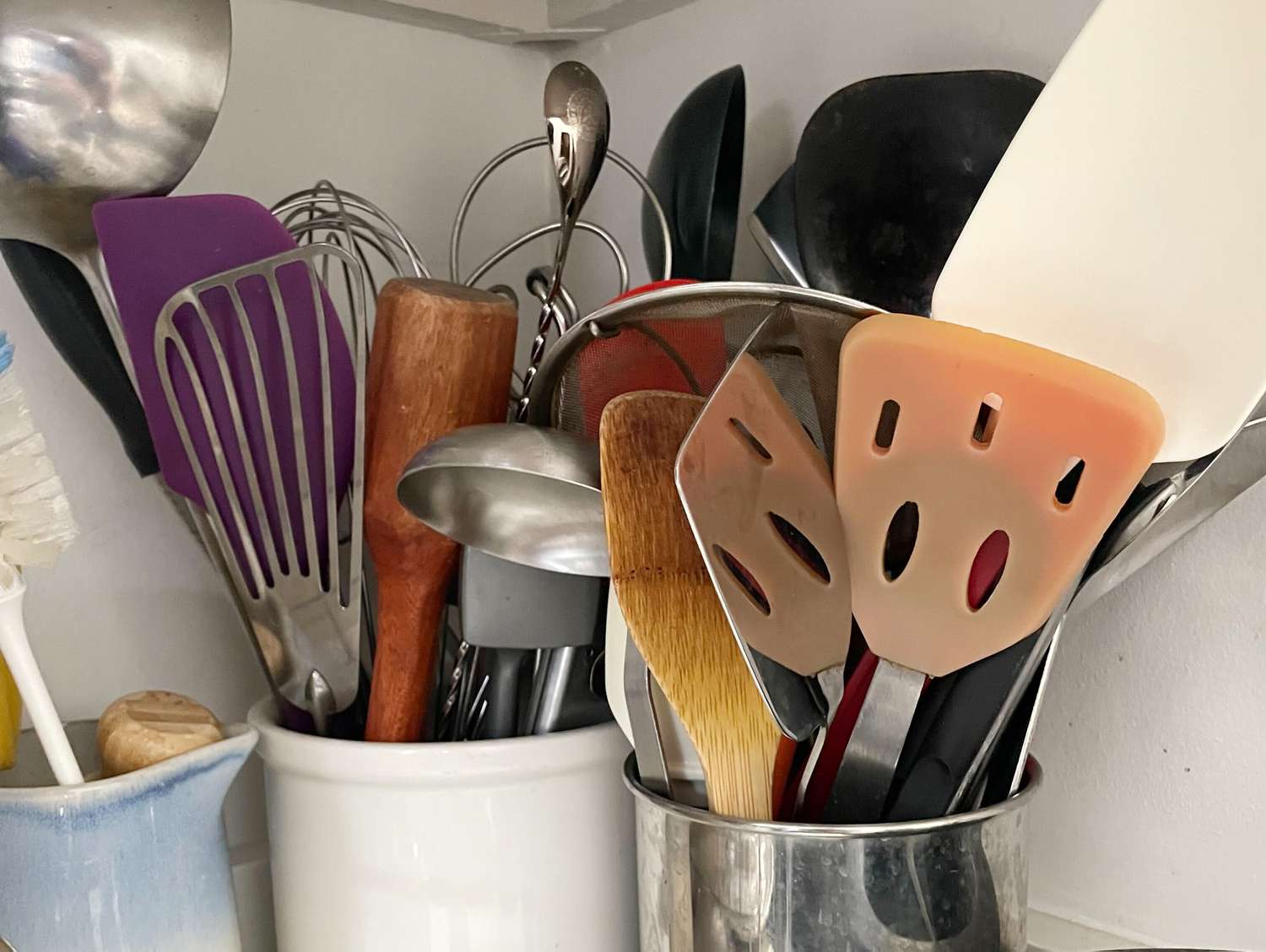 two utensil crocks side by side full of utensils