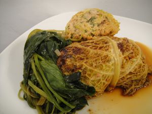 亚洲白菜卷配辣猪肉，配酱汁和绿色蔬菜。