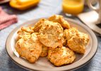 Several quick and easy drop biscuits on a plate with juice and butter in the background.