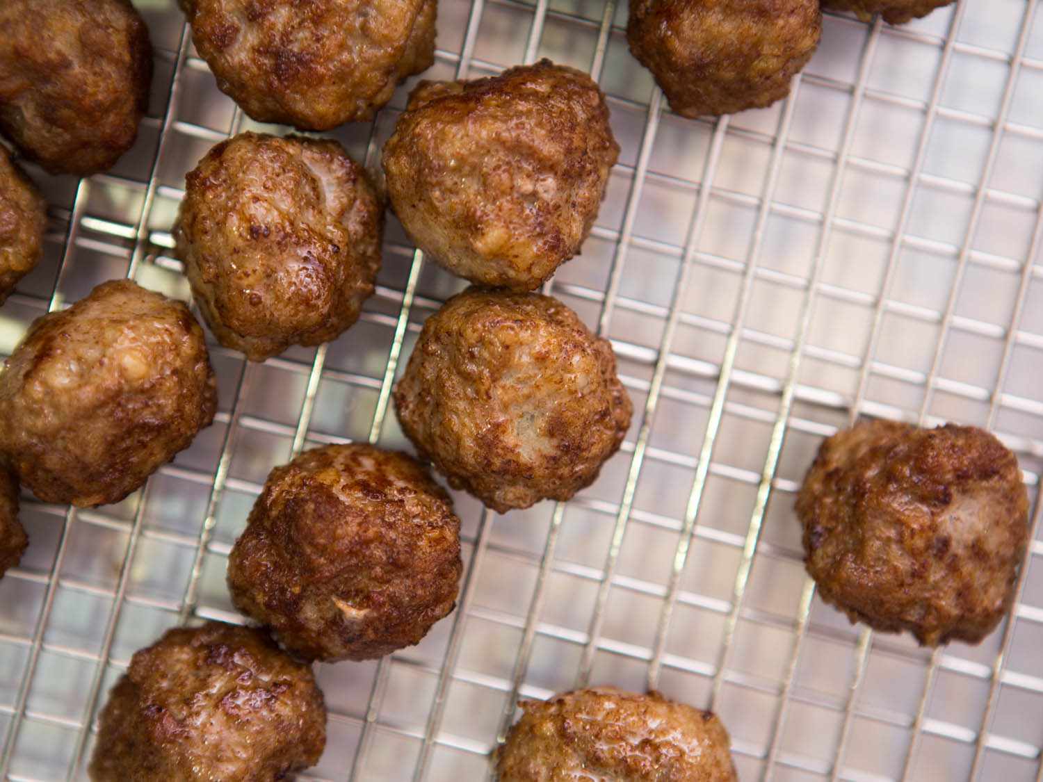 Top down view of a golden brown Swedish meatballs on a cooling rack.