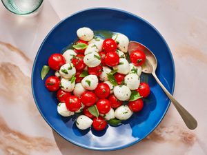 Marinated mozzarella, cherry tomato, and basil salad inside a dish