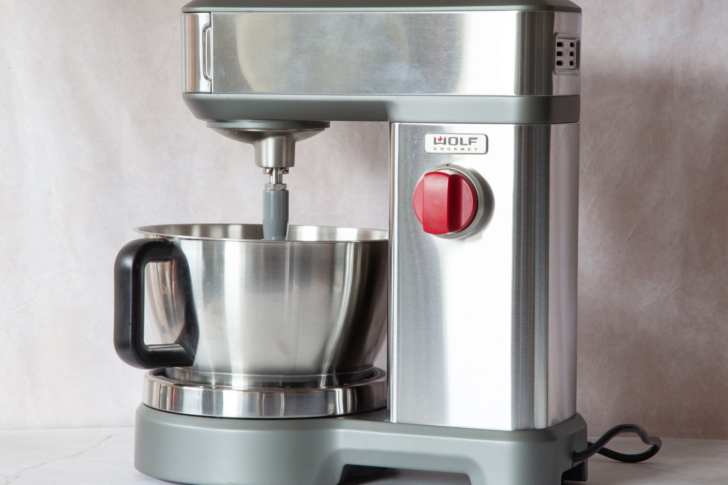 A stainless steel stand mixer on a marble surface