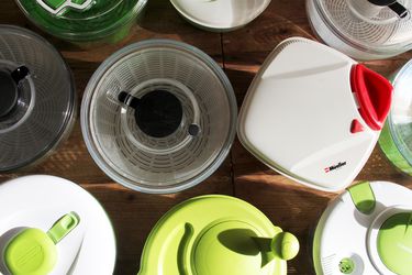 A bunch of salad spinners on a wooden countertop