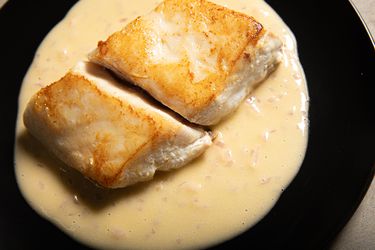 Overhead view of fish plated on top of Beurre Blanc sauce