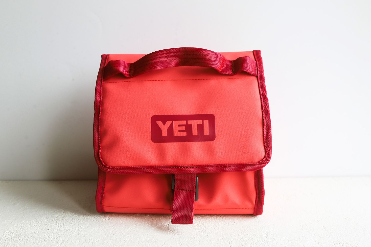 a pink and red Yeti lunch box on a white surface