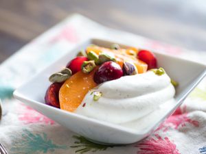 Whipped Greek yogurt topped with fruit and pistachio nuts.