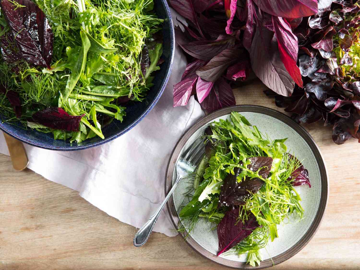 Overhead view of a Roman-inspired mixed green salad served at the table.