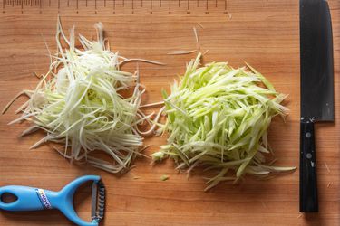 切菜板上用刀切和削皮切成丝的青木瓜