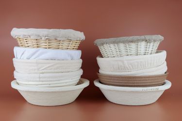 ten bread proofing baskets stacked on top of each other in two piles