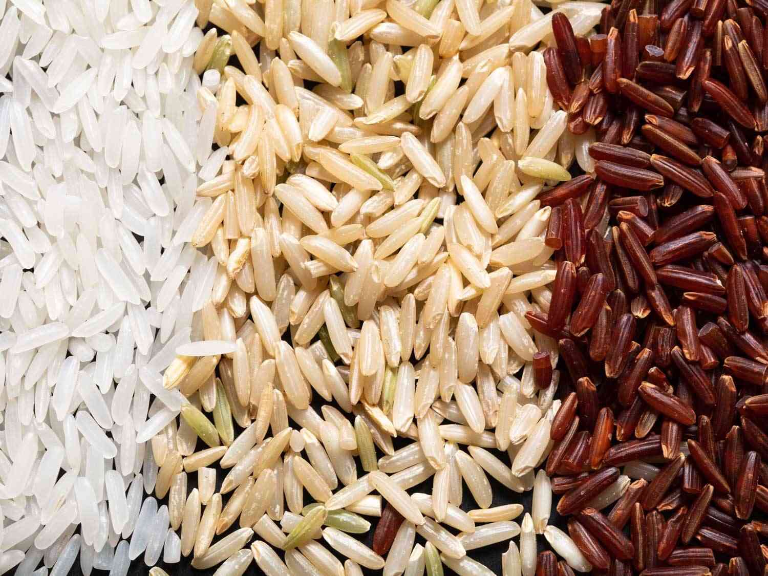A macro comparison view of polished, brown, and red jasmine rice