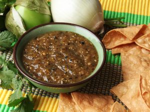 A bowl of charred salsa verde next to some tortilla chips.