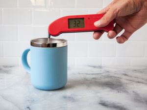 A person using a Thermapen ONE to take the temperature of ice water