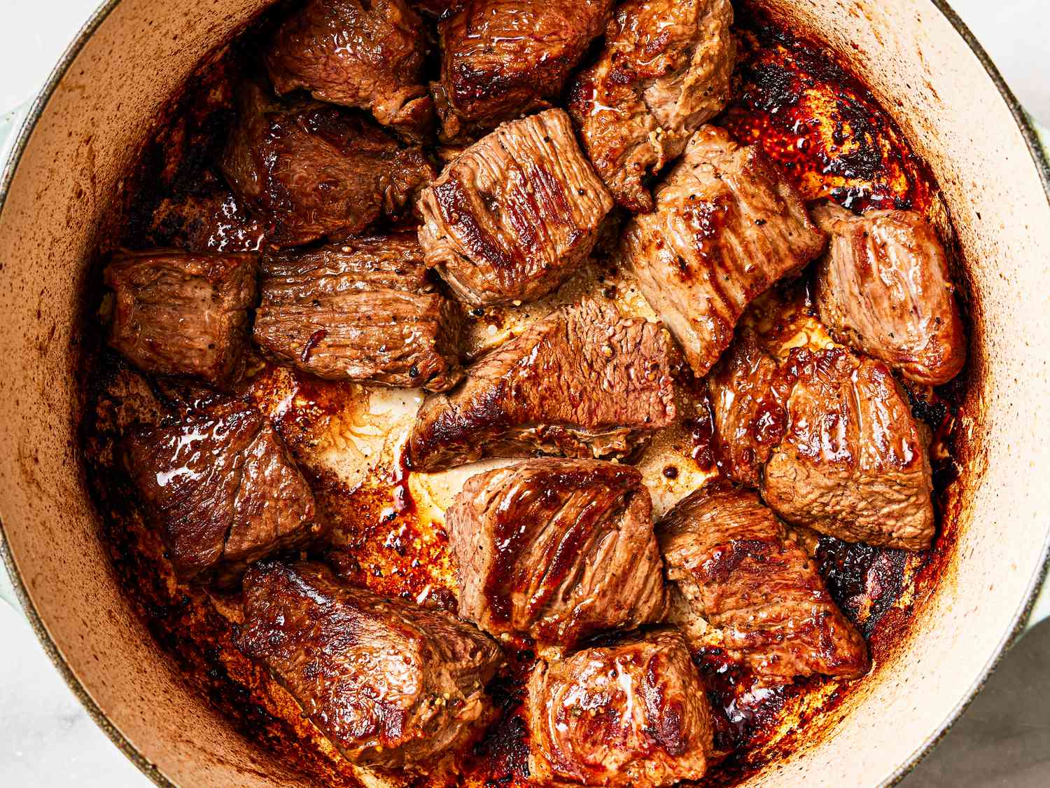Overhead view of meat deeply browned in dutch oven