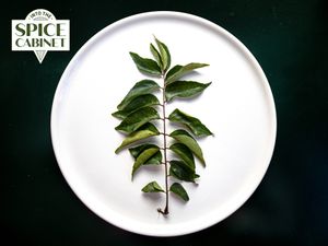 Curry leaves on a plate with Spice Cabinet badge