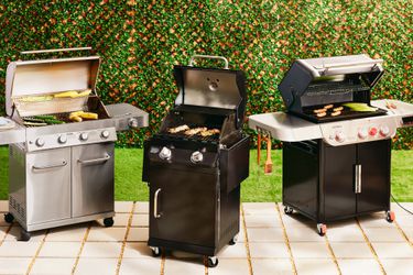 three gas grills on a patio