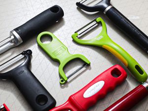 A closeup look at some vegetable peelers on a grey surface