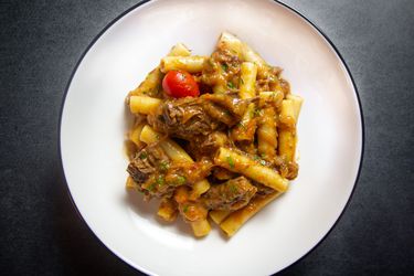 A plate of pasta alla Genovese made with ziti - or pasta with Neapolitan beef and onion ragù.