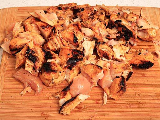 把烤鸡撕成碎片放在木板上。
