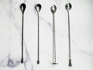 four bar spoons on a marble countertop
