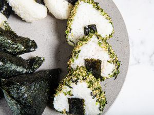 Overhead view of onigiri on a stone platter