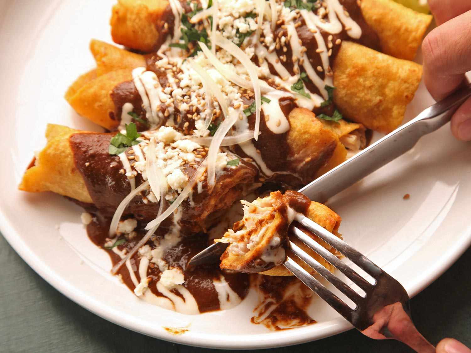 墨西哥玉米卷饼和墨西哥干酪放在盘子里，用叉子和勺子舀出一份。