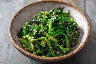 A small earthenware bowl of Korean marinated spinach.