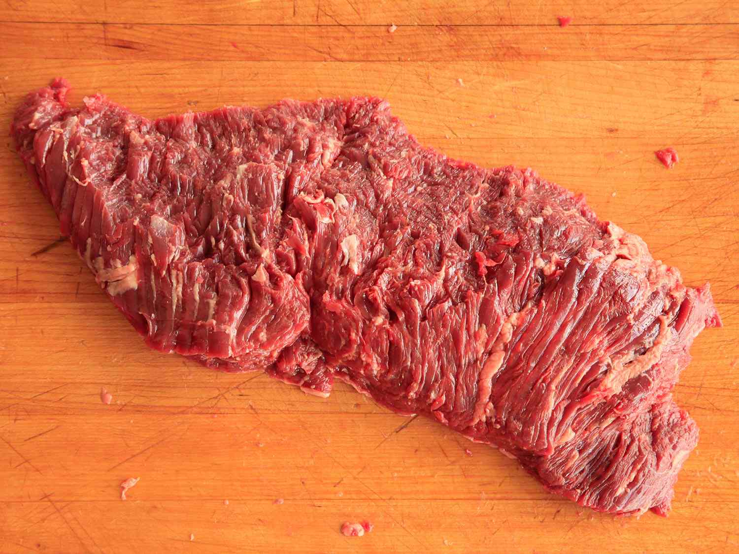 Raw flap steak on a wooden surface